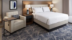 A hotel room with a bed, bedside tables, a sofa, and a patterned carpet. - Candlewood Suites Odessa Midland by IHG (Odessa)