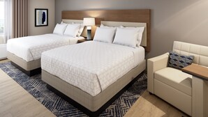 A hotel room with two beds, a sofa, a nightstand, and a lamp. - Candlewood Suites Odessa Midland by IHG (Odessa)