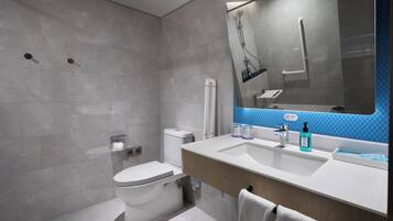 Et moderne badeværelse med toilet, håndvask og brusebad.