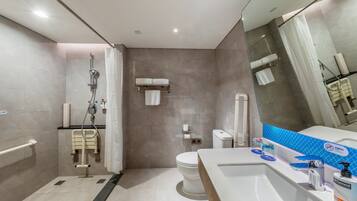 A modern bathroom with a shower, toilet, and sink.