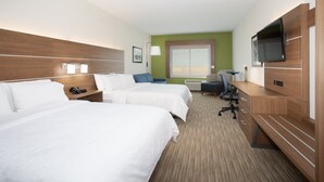 Une chambre d’hôtel avec deux lits, un bureau, une chaise, une télévision et une fenêtre.