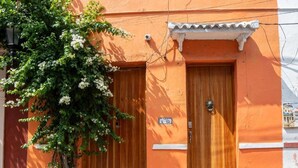 Ein Gebäude mit zwei Holztüren, einer kleinen Veranda und einem Blumentopf.