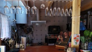 A kitchen with a wooden counter, hanging wine glasses, and a microwave. - Village house with large terrace.  (Valencia)