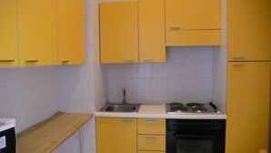 A kitchen with yellow cabinets, a sink, a stove, and a dishwasher. - ARBACANI HOLIDAYS (Gallipoli)