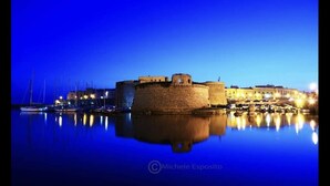 A historic stone castle with a moat, surrounded by a marina with boats. - ARBACANI HOLIDAYS (Gallipoli)