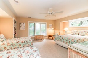A bedroom with two beds, a ceiling fan, a window, and a bookshelf. - DOG FRIENDLY Four Bedroom 3rd Row Ocean Sea Pines Home with a Private Pool (Hilton Head Island)