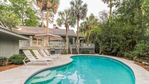 A swimming pool with lounge chairs, a covered patio, and a staircase leading to a deck. - DOG FRIENDLY Four Bedroom 3rd Row Ocean Sea Pines Home with a Private Pool (Hilton Head Island)