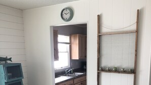 A kitchen with wooden cabinets, a sink, and a clock on the wall.
