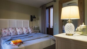 Ein Schlafzimmer mit einem Bett, einem Nachttisch, einer Lampe und einem Spiegel.