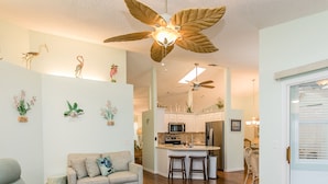 A spacious living room with a sofa, a coffee table, and a ceiling fan. - Jumpin Fish House 3BR/2BA Pool Home on the Canal (Sebastian)