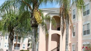 A multi-story building with a central courtyard, surrounded by palm trees and a well-maintained lawn. - Windsor_palms_303cp-n (Kissimmee)