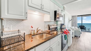A modern kitchen with white cabinets, a granite countertop, and a stainless steel sink. - WOW Perfect Honeymoon Getaway with Great Views (Myrtle Beach)
