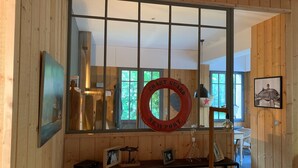 Een houten interieur met een grote spiegel, een reddingsboei en een ingelijst visje.