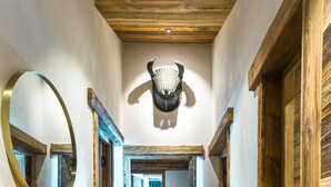 A wooden hallway with a mirror, a ceiling light, and a door leading to a room. - Top floor Apartment, amazing view, on the slopes ! (Val-d'Isère)