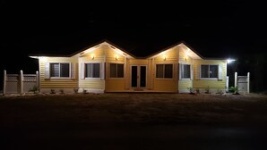 Una casa a due piani con una facciata simmetrica, un ingresso centrale con una porta doppia e un piccolo portico.