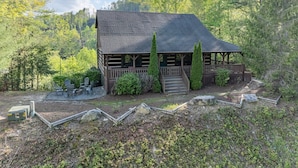 A log cabin with a porch, surrounded by trees and a clear sky. - Property not available (Vilas)