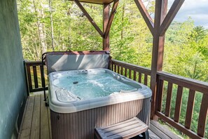 A hot tub on a wooden deck with a view of a forest. - Property not available (Vilas)