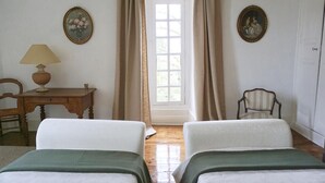A room with two beds, a desk with a lamp, a chair, and two framed pictures on the walls. - Ecrin des sens - Manoir en Agenais (Puch-d'Agenais)