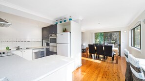 Una cocina moderna con una isla central, electrodomésticos integrados y un comedor con vistas.