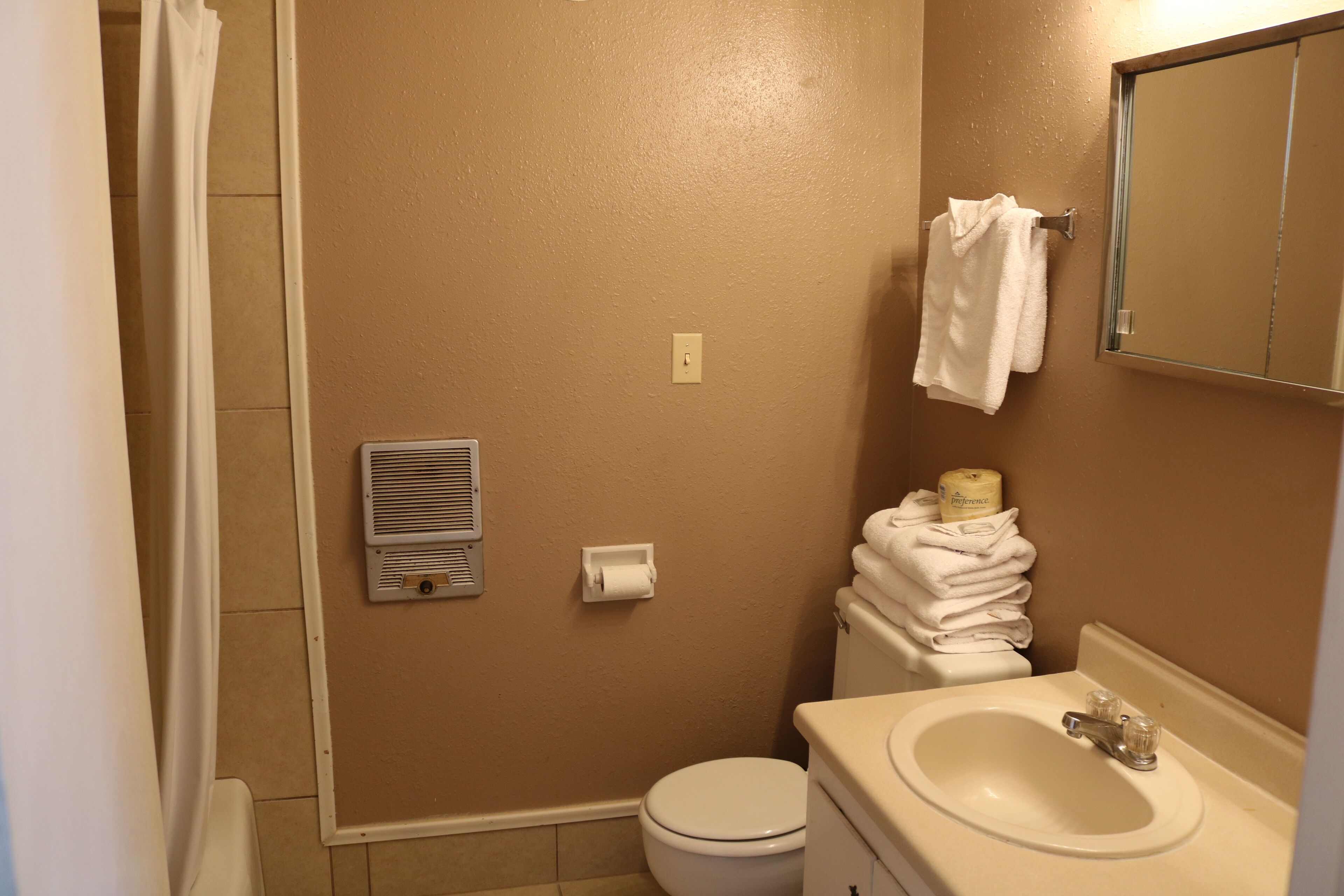 A bathroom with a toilet, sink, and towel rack.