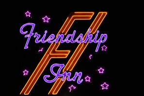 A neon sign with the words "Friendship Inn" and a stylized 'F' in orange and purple.