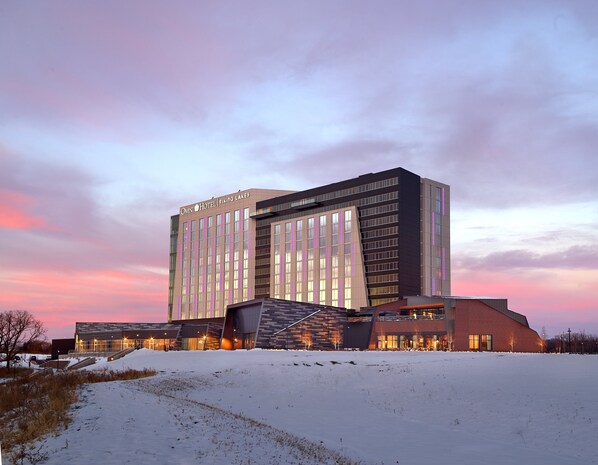 A modern hotel with a prominent sign, multiple floors, and a snow-covered ground. - Omni Viking Lakes Hotel (Eagan)