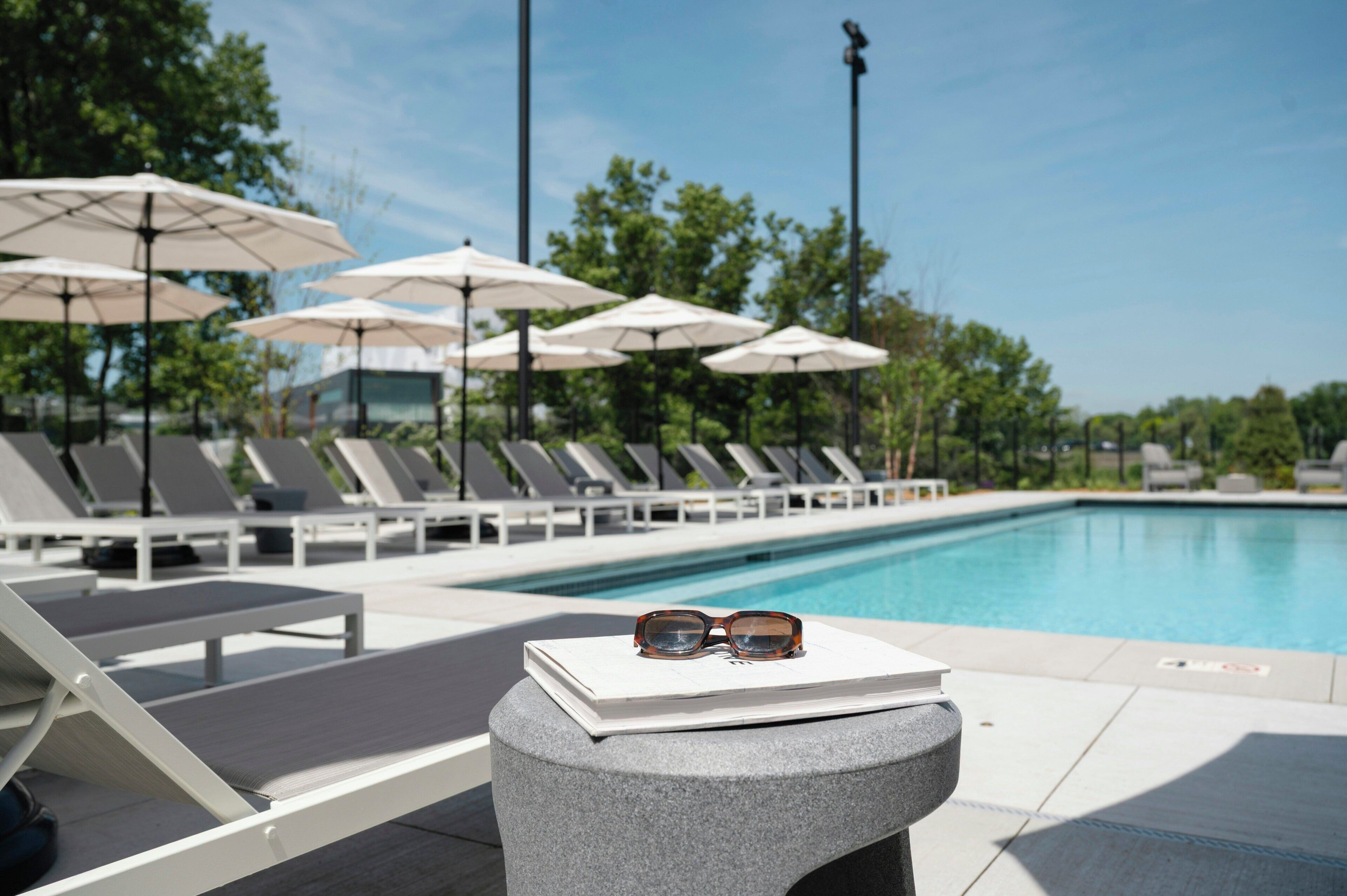 Una piscina techada, una piscina al aire libre, sombrillas