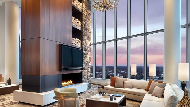 Una sala de estar moderna con chimenea, ventanas amplias y un rincón de asientos acogedor.