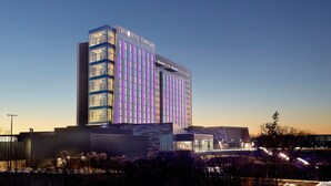 Un hotel moderno con una fachada de vidrio destacada y un cartel que dice 'OMNI Hotel Viking Lakes'.
