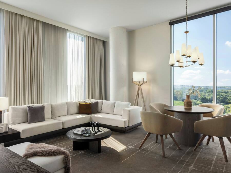 Una sala de estar moderna con un sofá modular, una mesa de centro redonda y vistas al exterior.