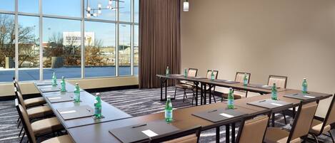 A conference room with a long table, chairs, and water bottles.