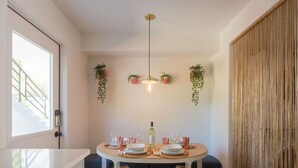 A dining area with a round table, chairs, and hanging plants. - Stylish & Eclectic Modern 2/2 Apt - WeArePeaceful (South Pasadena)