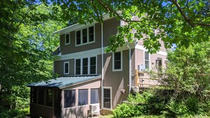 A two-story house with a covered porch and a small shed. - 1810 Brook Side Mill/House / EV Level 2 Charging on Site (Shelburne Falls)