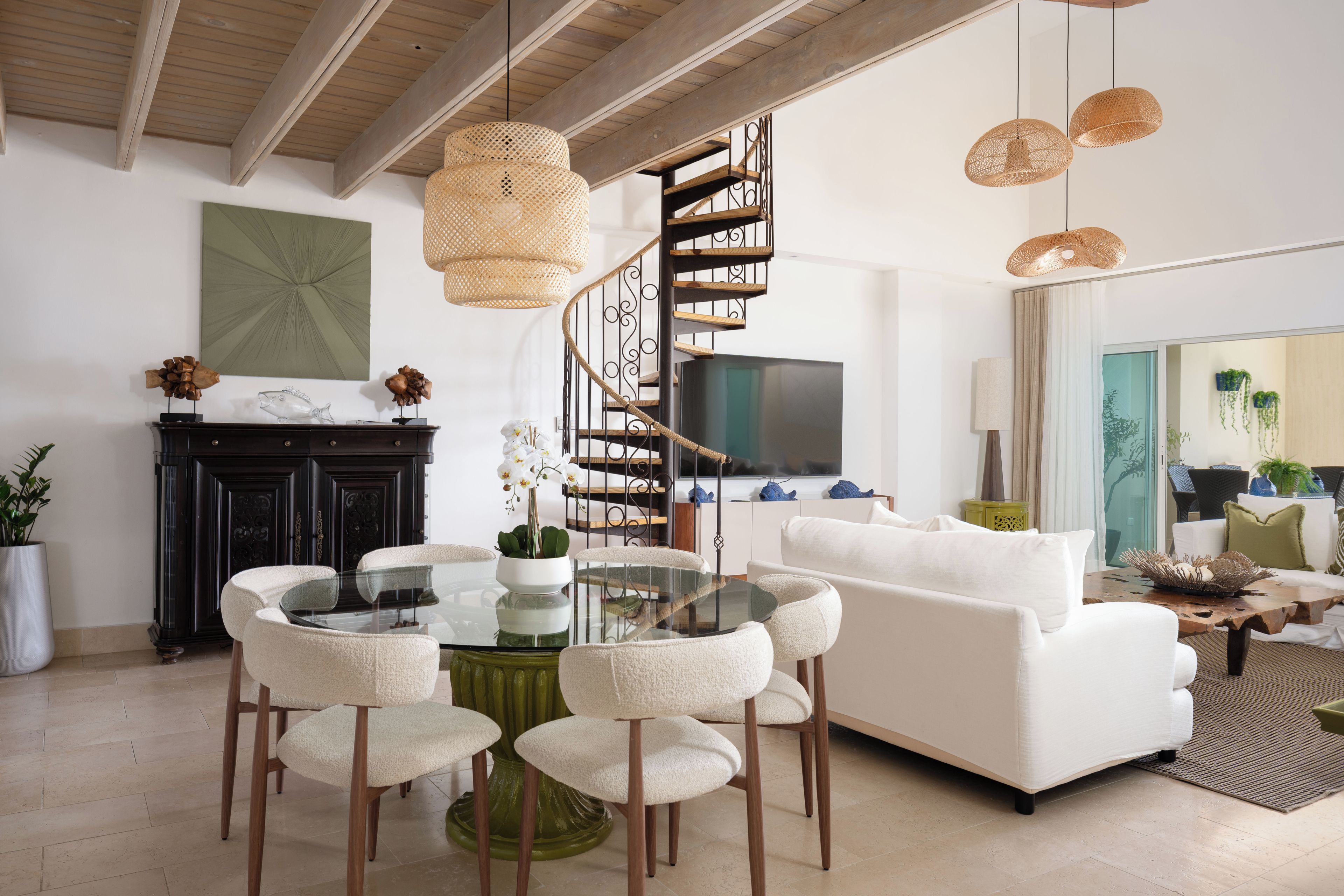 Ein modernes Wohnzimmer mit einem Glastisch, weißen Sofas und einer Wendeltreppe.