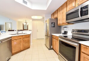 A modern kitchen with wooden cabinets, stainless steel appliances, and a central island.