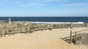 A beach with a wooden fence and a sign warning to keep off the dunes. - 1BR Condo Beach Block Location – Under 500 feet to the Beach & Boardwalk (Ocean City)