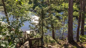 A wooden boardwalk leading to a lake surrounded by trees. - Treehouse on the river. (Au Train)