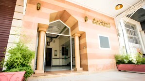 A hotel entrance with a modern design, featuring a glass door and a sign in a foreign language. - Hotel Olympic (Fes)