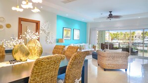 A modern hotel lobby with wicker furniture, a large mirror, and a view of the outdoors.
