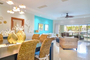 A modern hotel lobby with wicker furniture, a large mirror, and a view of the outdoors. - Luxury Marina Front Condo Cap Cana, Punta Cana (Cap Cana)