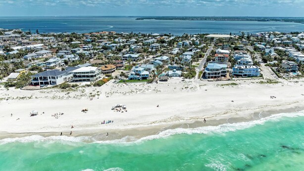 An aerial view of a coastal residential area with houses, a beach, and the ocean. - Single Level Home- 1 Minute Walk to the Beach- 5 minute walk to Restaurant/Shops (Holmes Beach)