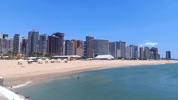 A beachside cityscape with modern high-rise buildings, a sandy beach, and umbrellas. - Excellent fit 2 bedrooms fully furnished, cable TV, sea view from the balcony (CE)