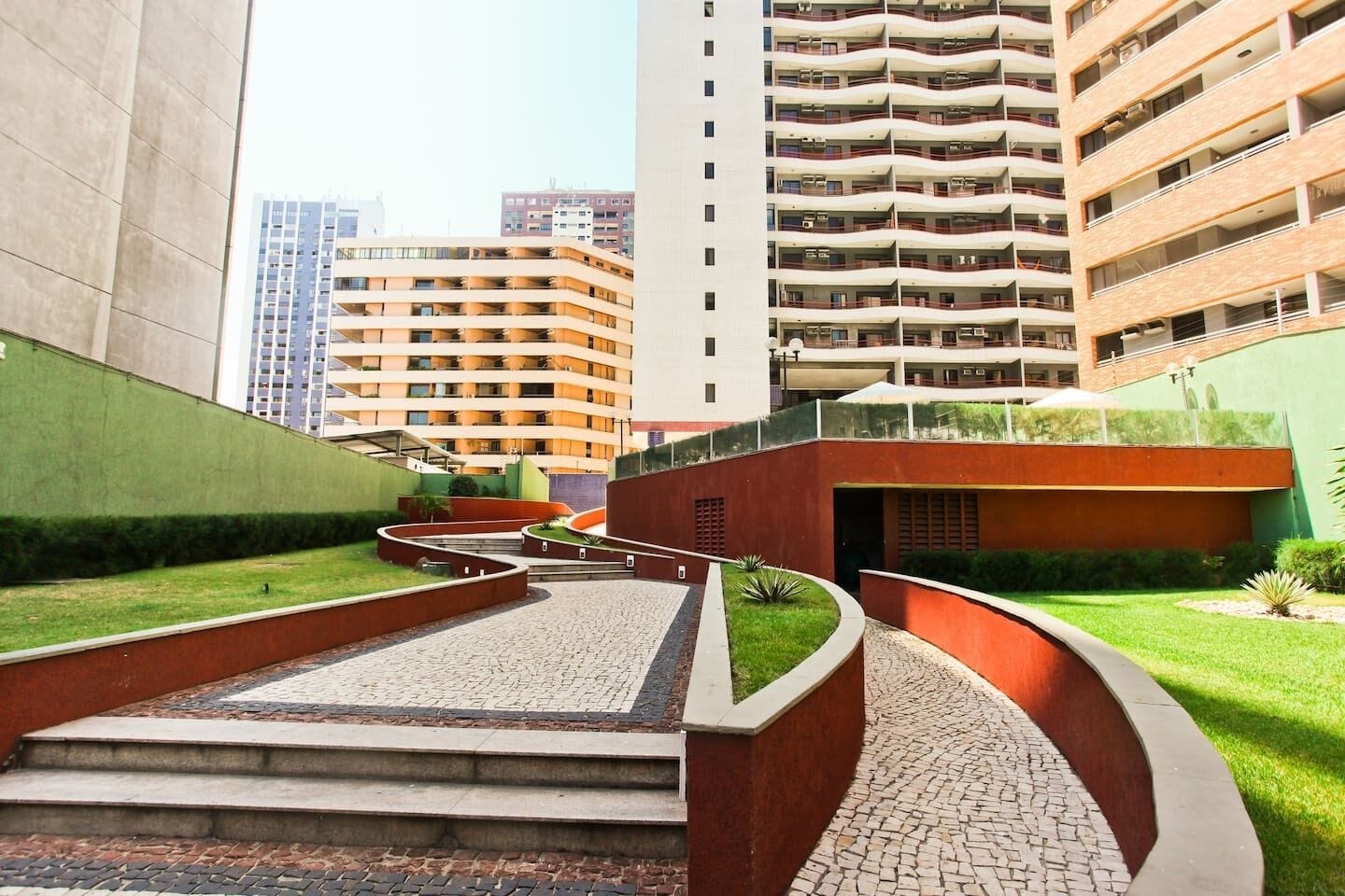 Um edifício moderno com um pátio central, rodeado por apartamentos altos.