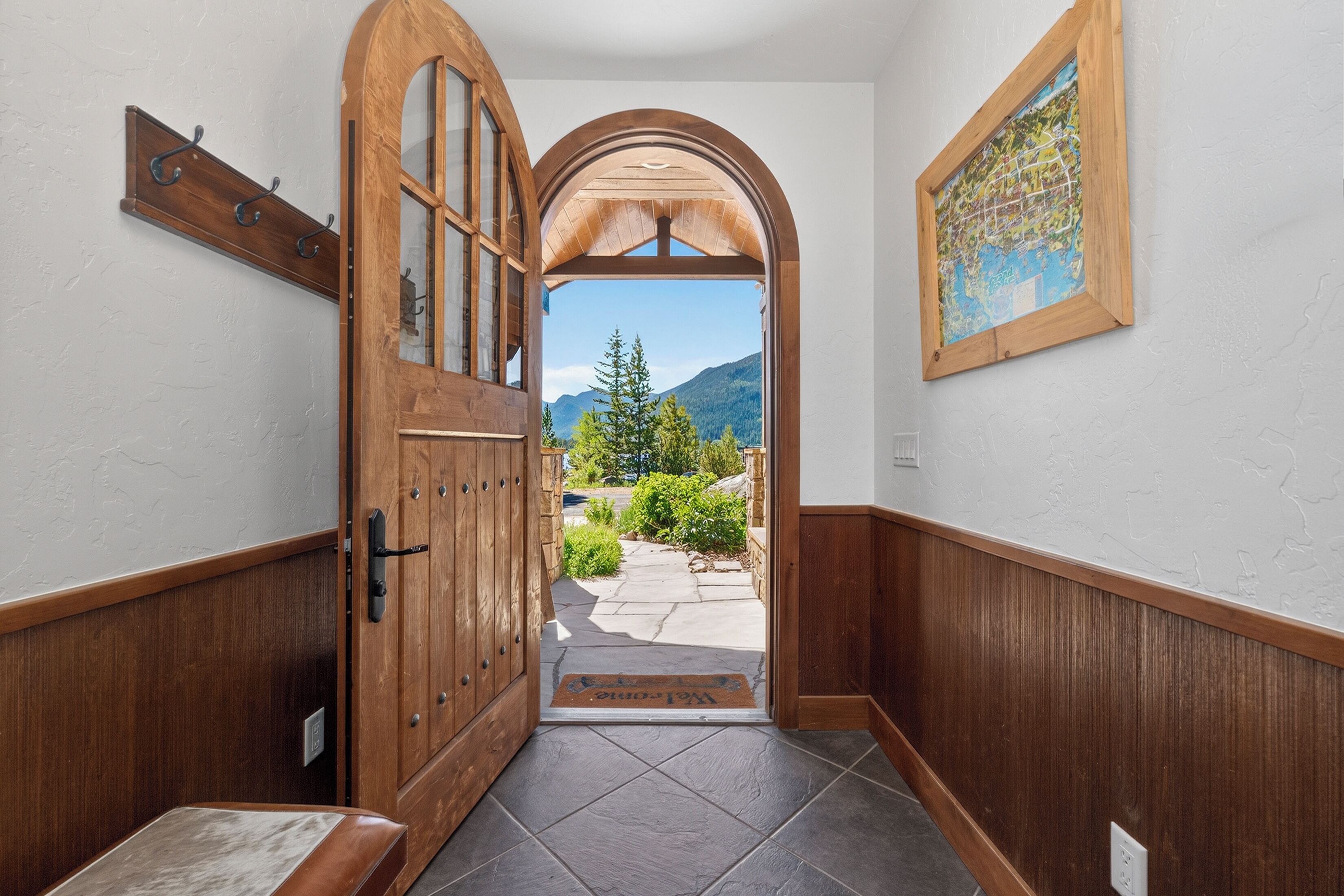 A wooden hallway with a door leading to a scenic outdoor view.