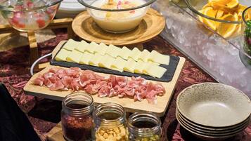 A buffet with various food items including cheese, meat, and condiments.