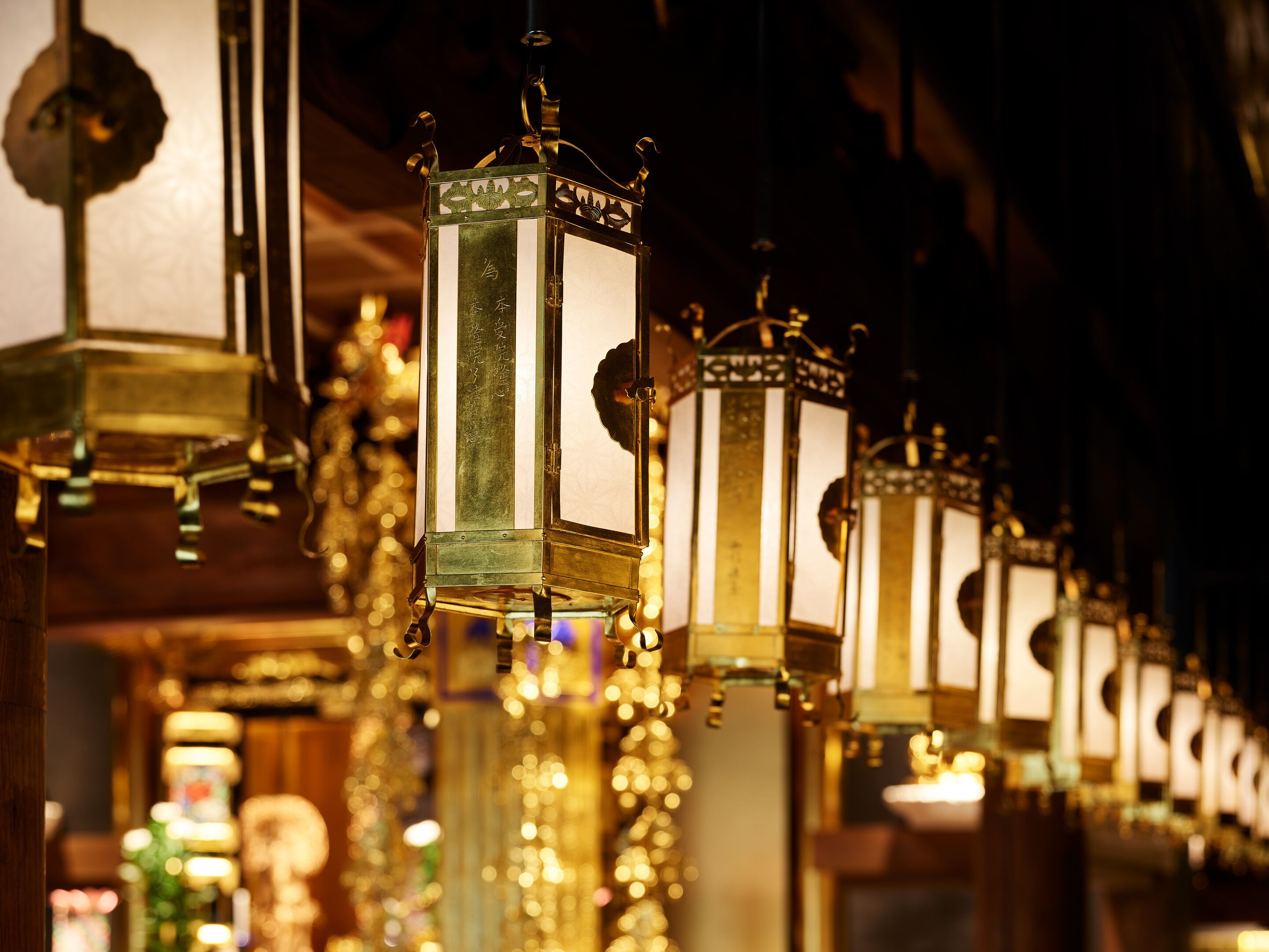 A row of ornate, illuminated lanterns with intricate designs, likely part of a decorative interior.
