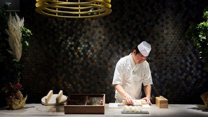 A chef preparing sushi in a modern kitchen with a hexagonal tile backsplash and a hanging light fixture. - Mitsui Garden Hotel Kyoto Kawaramachi Jokyoji (Kyoto)