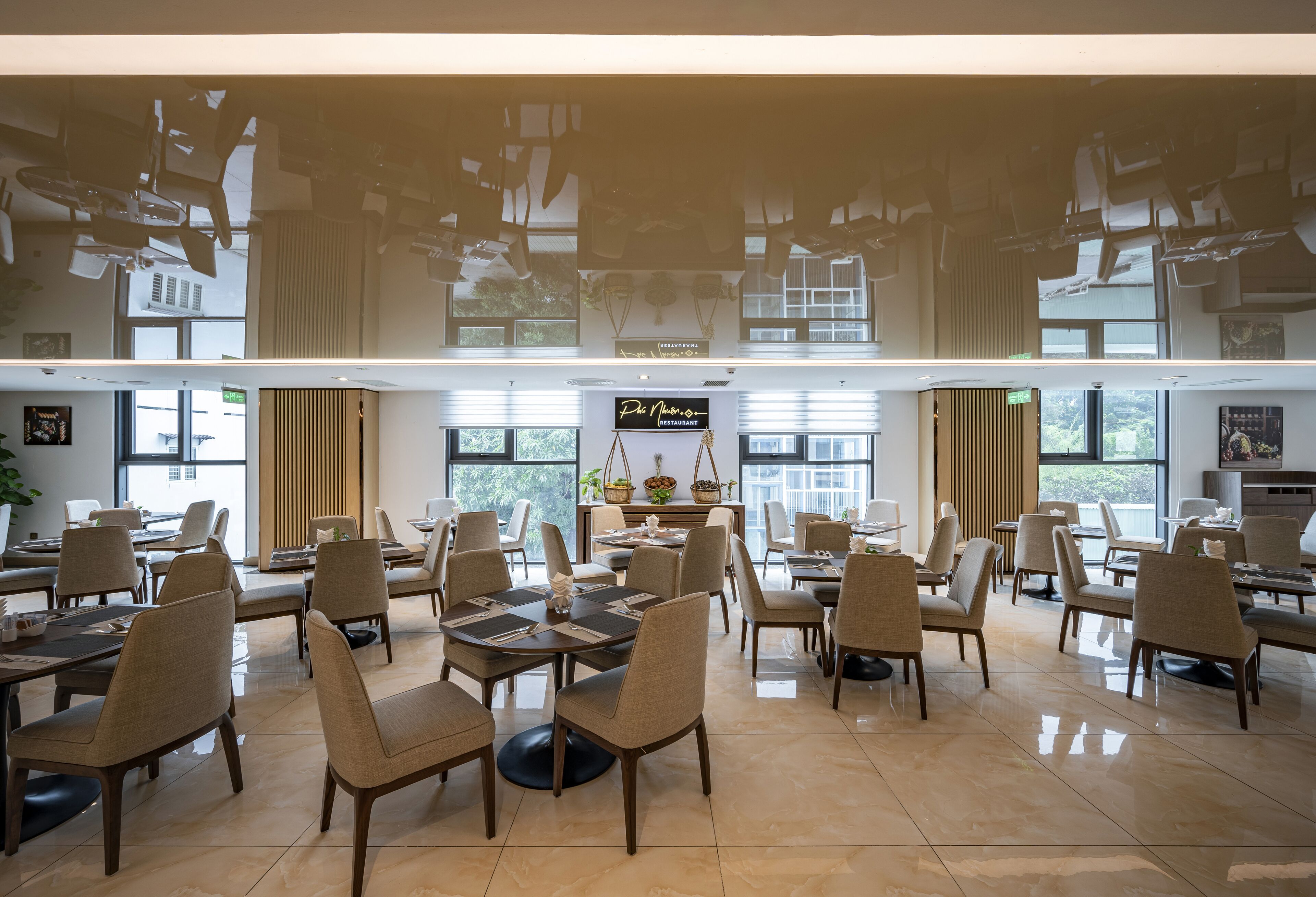 Un restaurante espacioso con techos altos, varias mesas y sillas dispuestas en una distribución moderna.
