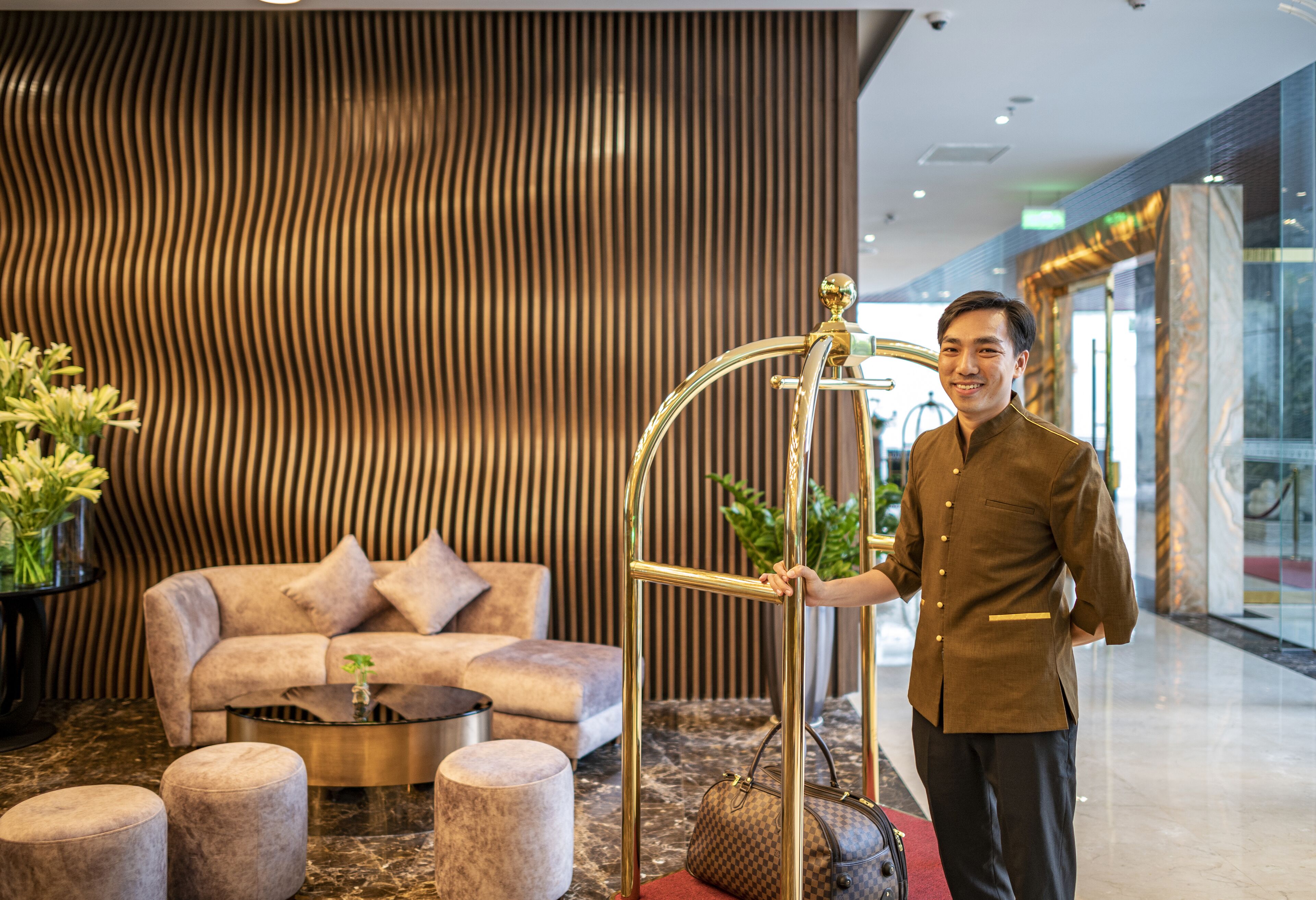 A modern lobby with a sofa, ottomans, a coffee table, and a decorative metal railing.