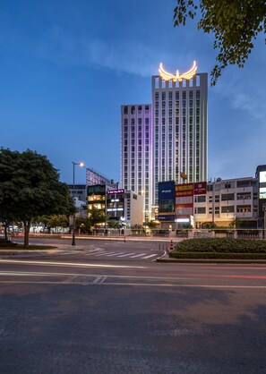 A modern high-rise building with illuminated signage and a prominent wing-like structure on top. - Muong Thanh Luxury Saigon Hotel (Ho Chi Minh City)